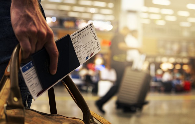 Passenger in airport holding passport and boarding pass