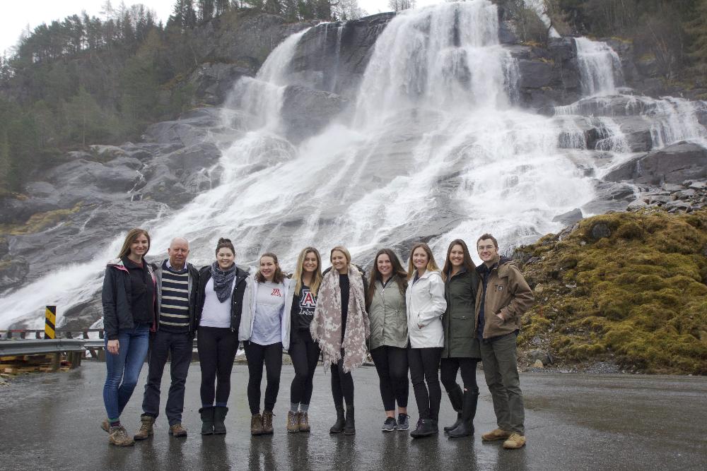 Students posing in front of a waterfall in Norway