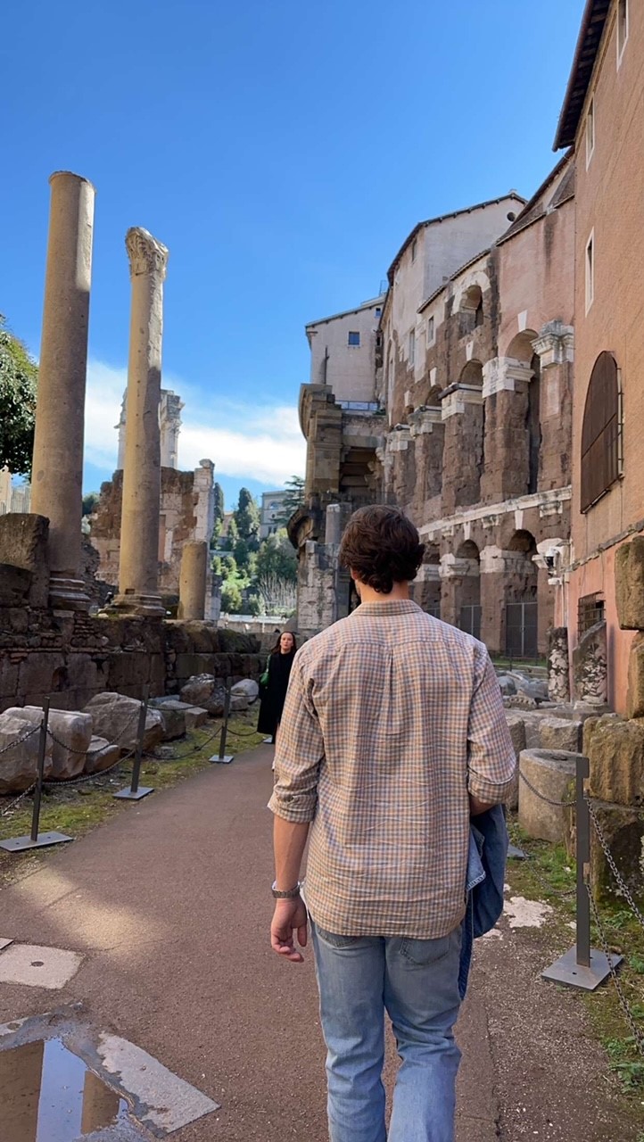 student walking in front of Rome ruins